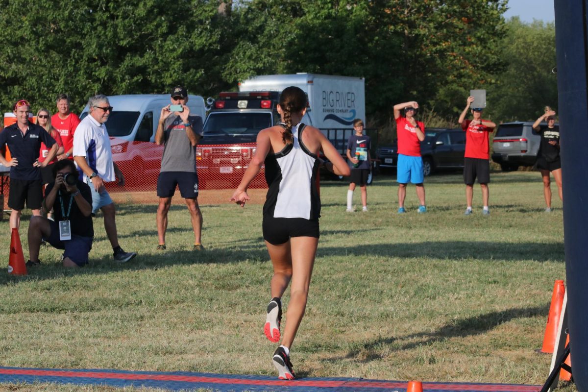 Crossing the finish at the Forest Park Invitational on Sept. 13, freshman Bella Burlbaw completes the race in 2nd place.