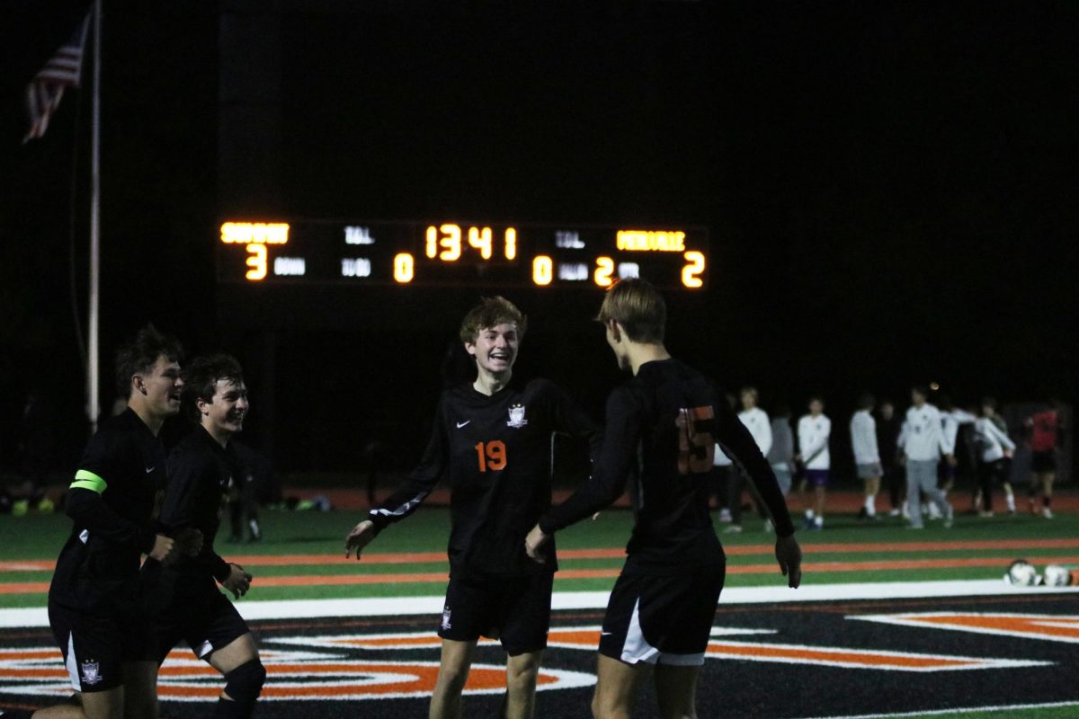 Junior Blayne Douglass (19) celebrates with senior Will Sanders (15) after scoring the final goal for the Falcons in the second half.