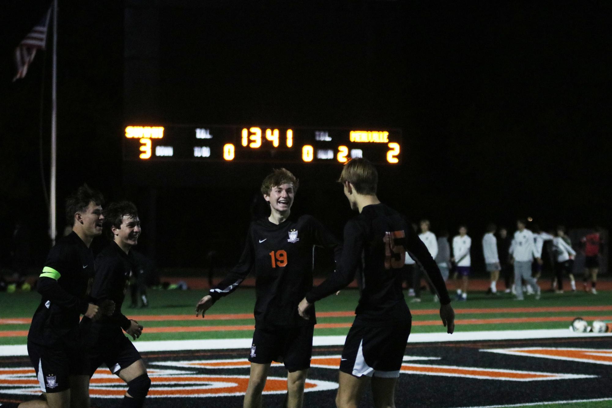 Junior Blayne Douglass (19) celebrates with senior Will Sanders (15) after scoring the final goal for the Falcons in the second half.
