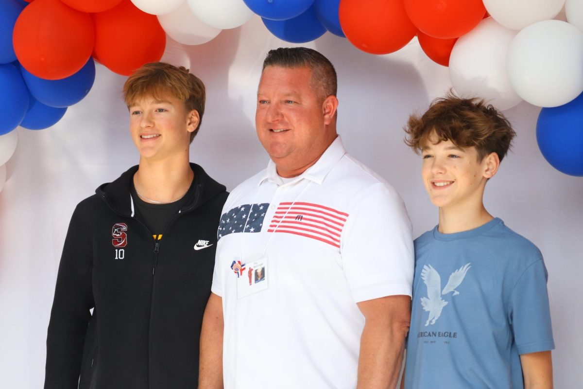 Junior Chase Barringer, and freshman Bryce Barringer pose with their dad Jay Barringer for a photo. The veterans day celebration took place on Nov. 7 and included a multitude of festivities.