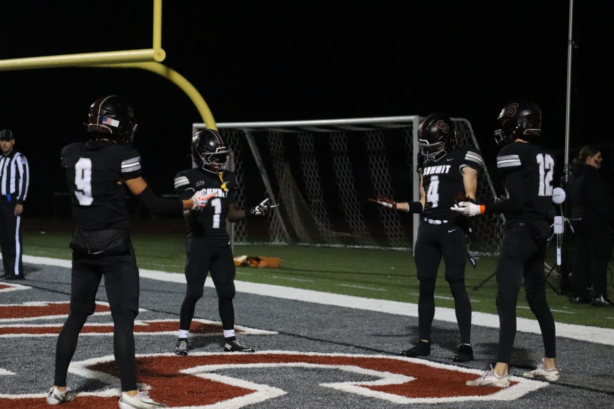 Senior Connor Polsak (9), junior Kindall Young (1), and seniors Rowan Jackson and Connor Zerr (12) celebrate with an imitation of the "Spider-Man" pointing meme. The game was scheduled for Oct. 30, so many people celebrated Halloween by showing up in themed outfits or costumes.