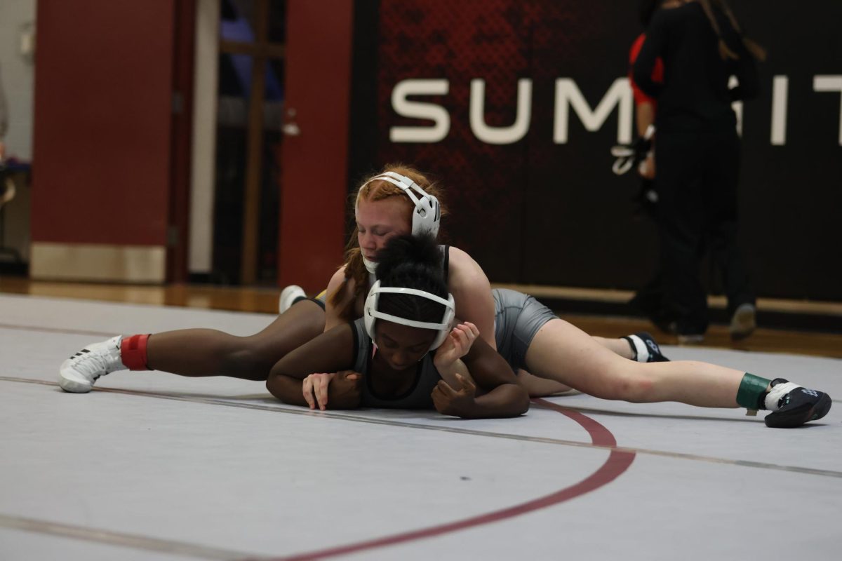 Grabbing under her shoulders, freshman Delaney Pye holds down her opponent. The Summit Girls Wrestling team placed fourth out of 22 teams on Jan. 16.