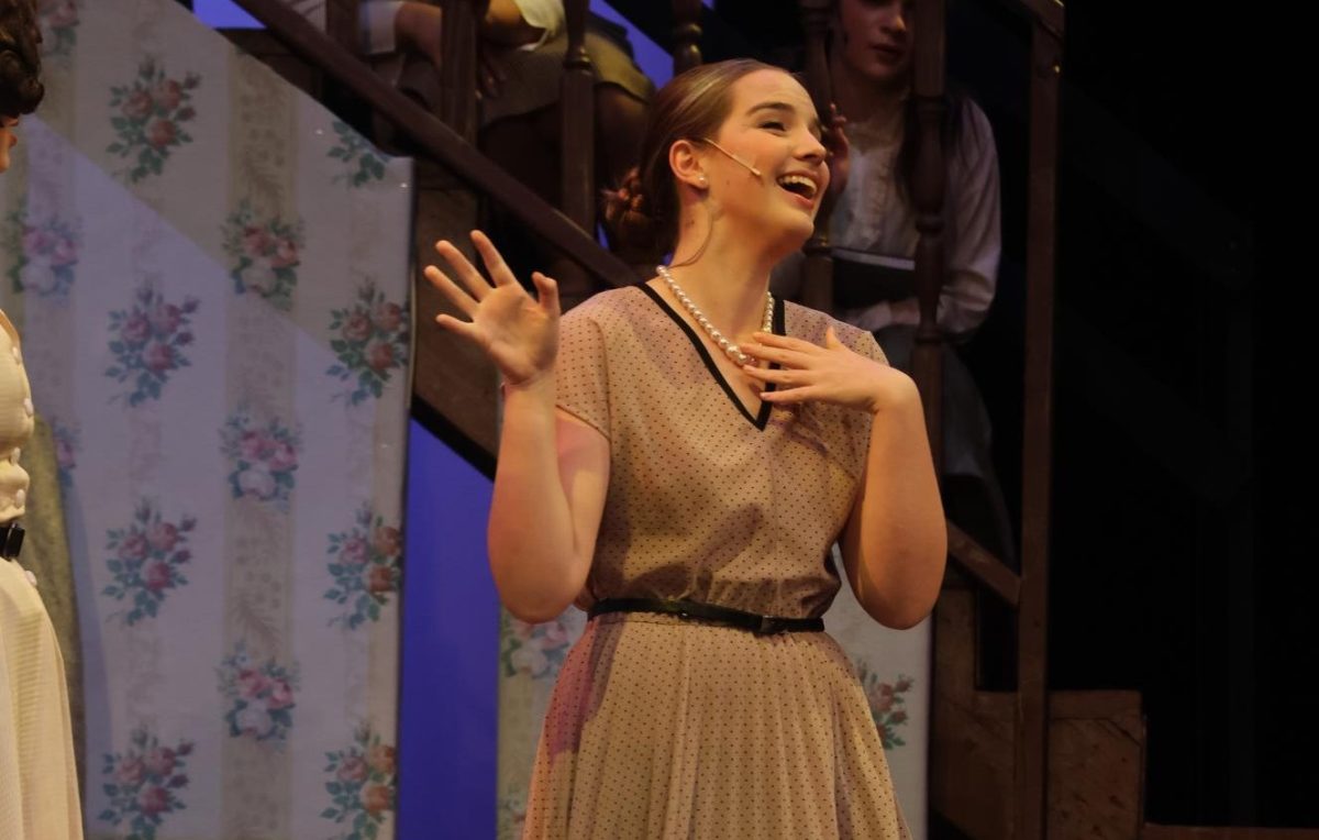 Smiling, junior Becca Wirthlin (Mrs. Lily Mortar) looks out into the crowd. The Falcon Players first performed their show at Summit on Nov. 13-15.