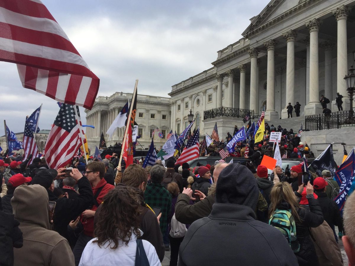 Storming the Capitol Building, Americans on Jan. 6 hold flags and signs in protest of the results of the 2020 election. Thousands of people broke into the Capitol Building while Congress was in session in an effort to stop the confirmation of Joe Biden’s presidency. (photo from Progressive Policy Institute) 