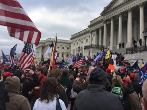 Storming the Capitol Building, Americans on Jan. 6 hold flags and signs in protest of the results of the 2020 election. Thousands of people broke into the Capitol Building while Congress was in session in an effort to stop the confirmation of Joe Biden’s presidency. (photo from Progressive Policy Institute)