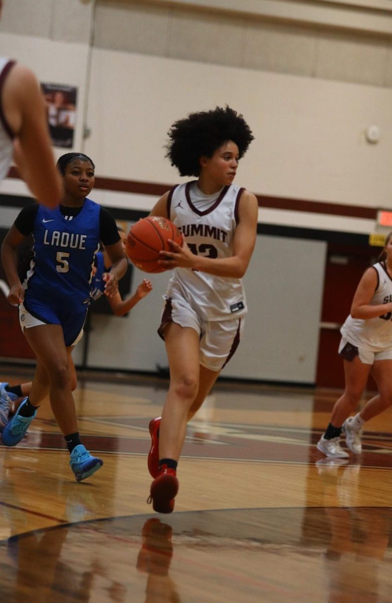 Taking the opportunity, sophomore Annalise Brewer-Moore dribbles the ball down the court after gaining possession. The Falcons lost to the Ladue Rams with a score of 55-31 on Jan. 9.