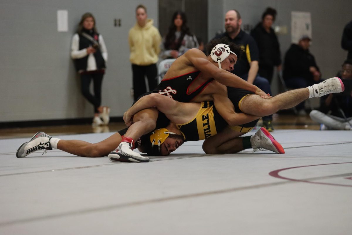 Holding down his opponent, junior Donovan Brown wraps his hands around Oakville's Gokkhan Yurdanidze's leg. Brown, among two other Summit wrestlers, placed fourth in his weight class on Jan. 17 at the Route 141 Rumble tournament.