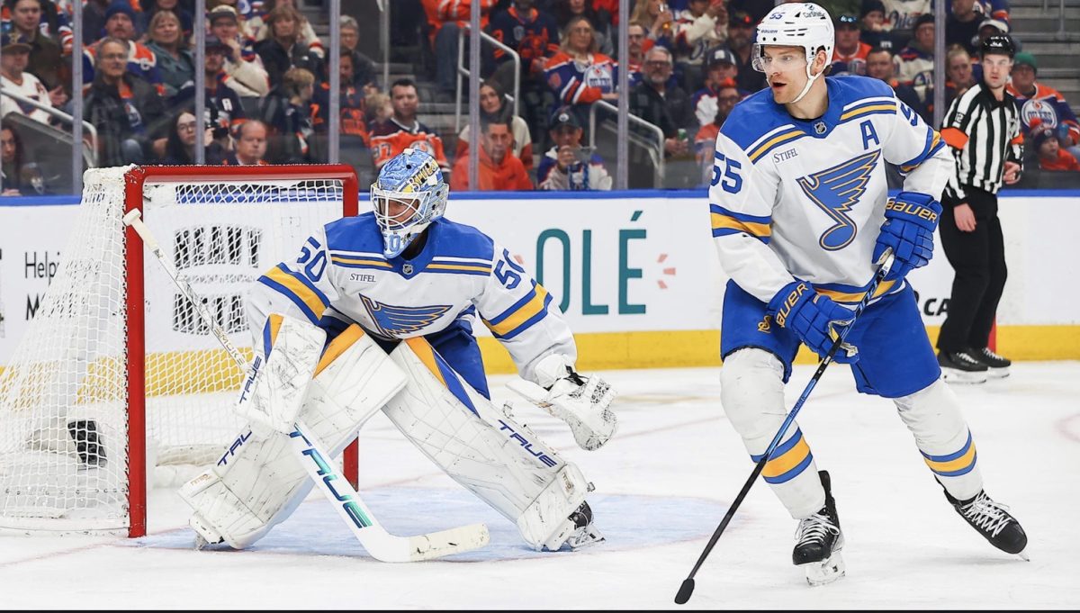 In a game against the Edmonton Oilers on Jan. 18, goaltender Jordan Binnington (50) and defenseman Colton Parayko (55) guard the net. The two will join 23 other players to form Team Canada at the 2026 Winter Olympic Games in Milan and Cortina d'Ampezzo, Italy. (photo from St. Louis Blues)