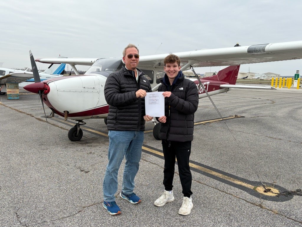 Receiving his private pilots license, senior Adam Kovarik stands with an examiner from the Federal Aviation Administration. Kovarik passed his check ride on Dec. 11, clearing him to fly privately. (photo used with permission by Kovarik)
