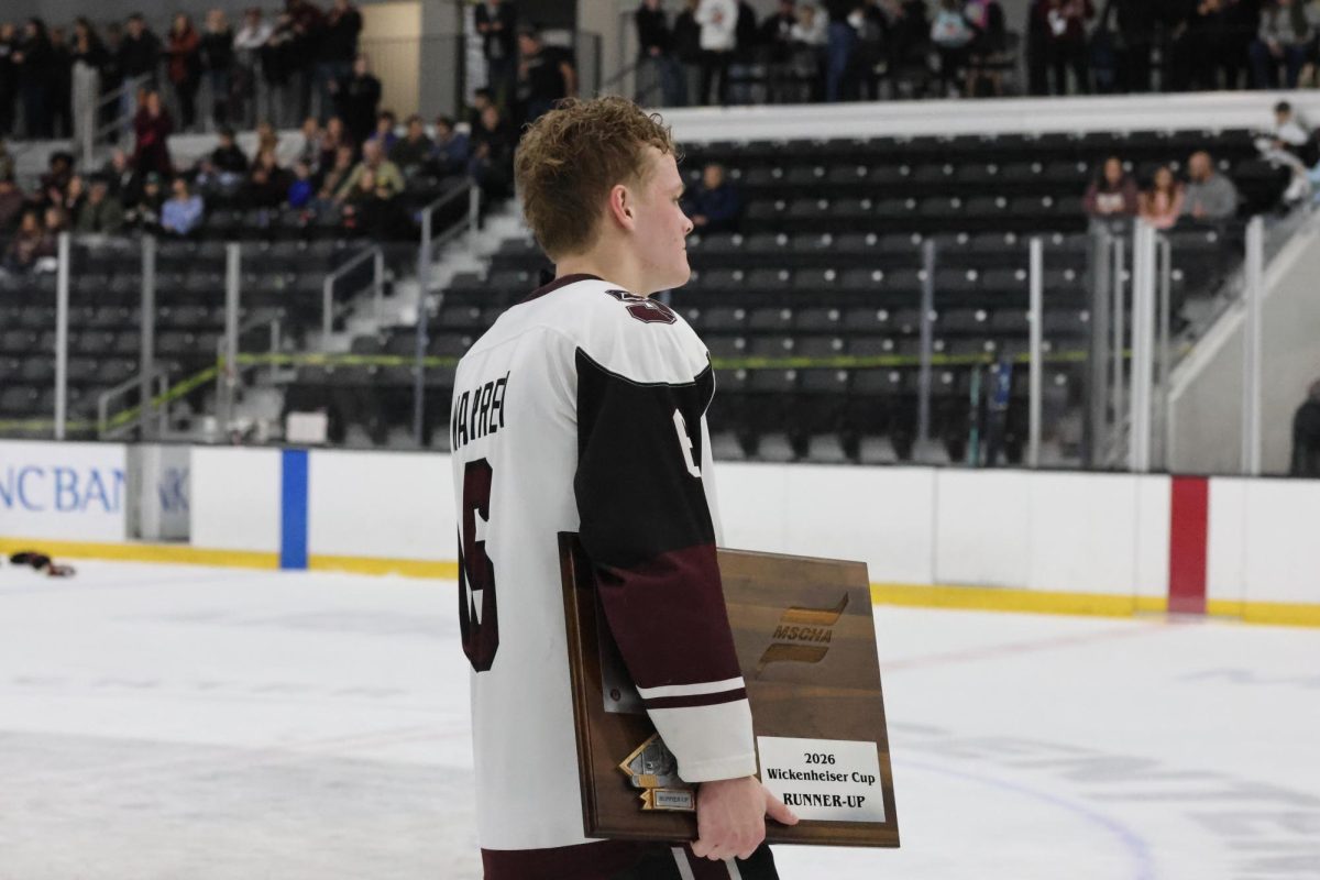 Skating back to his team, junior Blake Warren holds the "runner-up" plaque. The Falcons fell just short of gold in the playoffs, being undefeated throughout the quarter and semifinals.