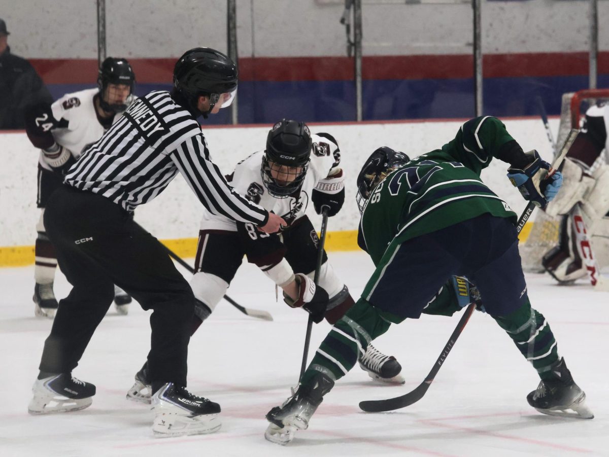 Preparing for the faceoff, junior Conrad Wecker watches the puck. The Falcons were victorious against the Wolves on Feb. 2 at Affton Ice Arena.