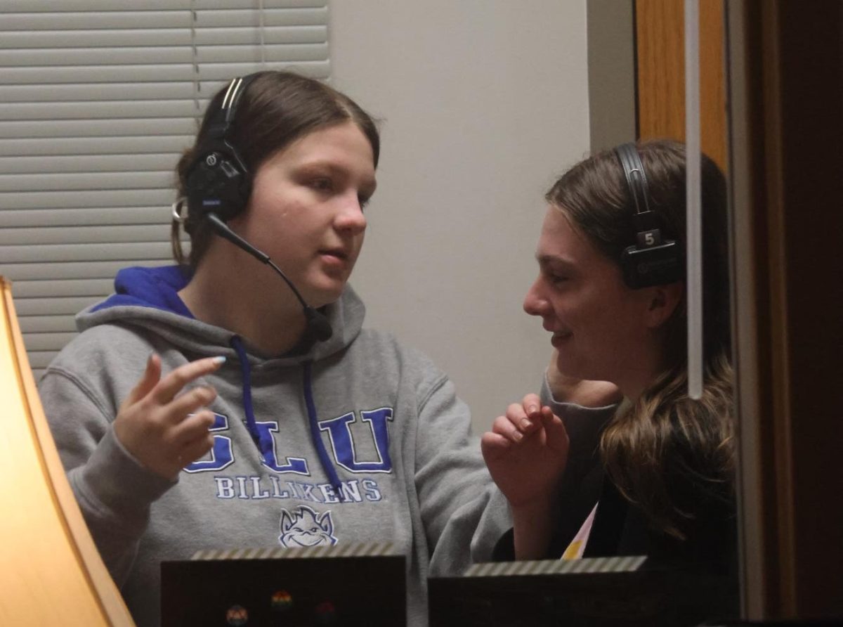 Putting on headsets, sophomore Audrey Marsalek and senior Lauren Laffleur prepare for the one-act. 