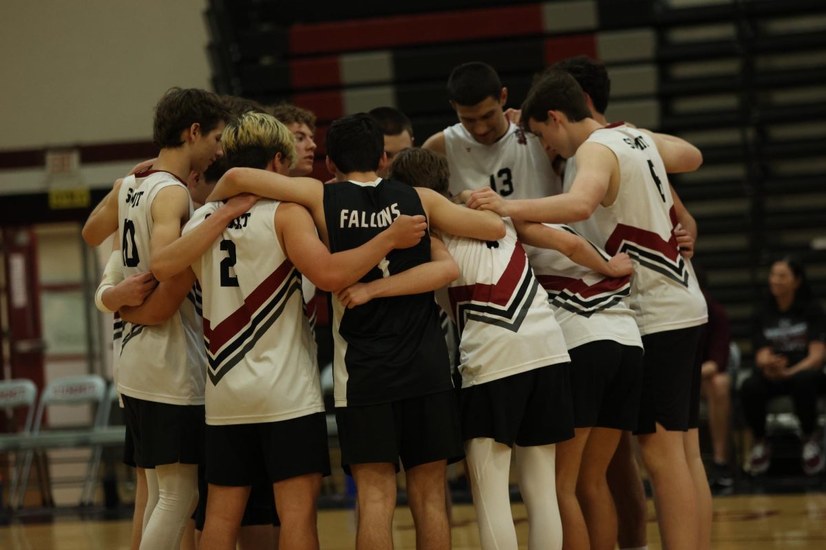 The Boys Varsity Volleyball team huddles before their game. The game took place against Lindbergh in the main gym.