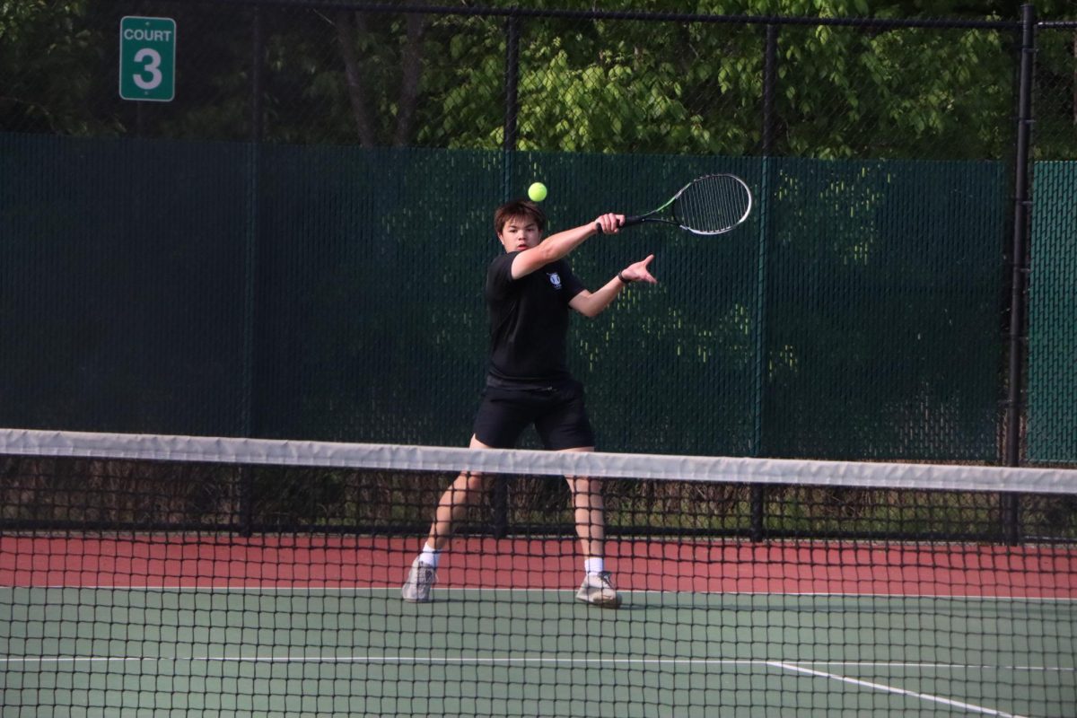 Returning the ball, junior Nick Nguyen swings his racket. Nguyen played on court three during the match against Mehlville.