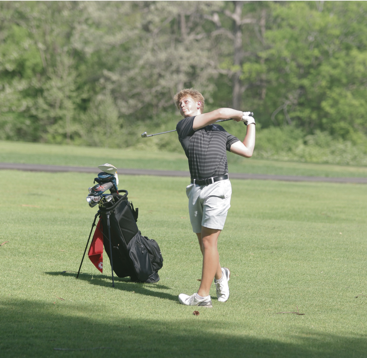 Watching his shot, junior Sam Catalano stands on the fairway. Catalano shot a 45 at Caste Bluff Country Club on April 16. 