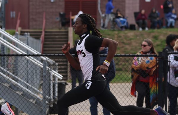Sprinting, junior Kobi Barton pumps his arms. Barton placed third in the boys varsity 300 Meter Hurdles event at the Rolland Garrison Invitational.