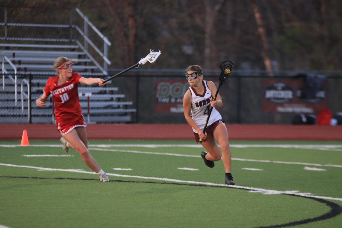 Avoiding Margot Newbold (10) of Visitation, junior Bianca Carlson (4)  runs downfield.